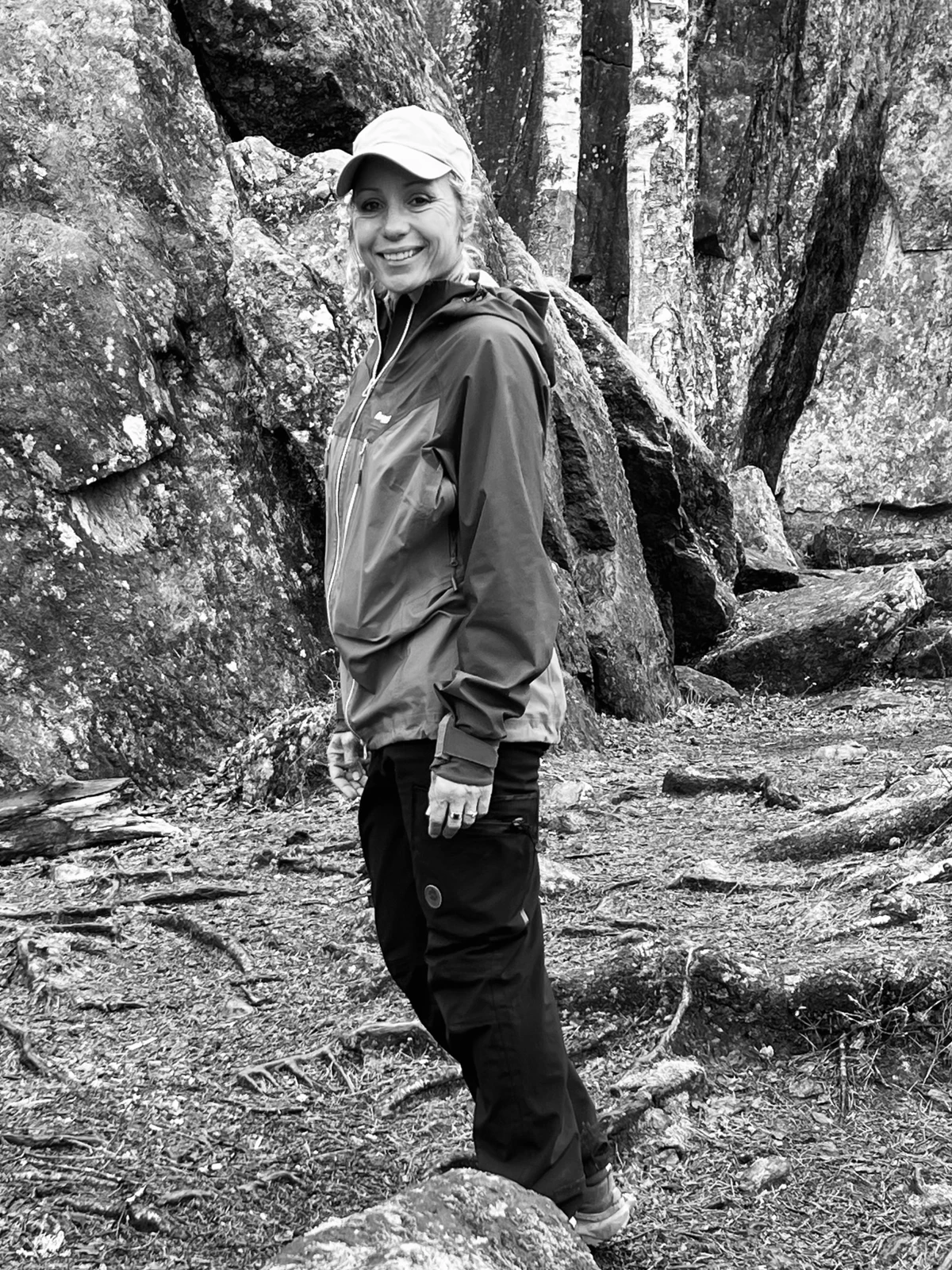 Silje på tur mellom trær og berg i skogen